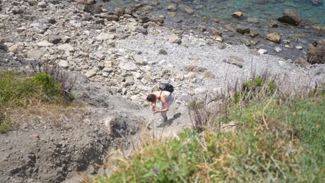 girl climbing over cliff in cinque terre.