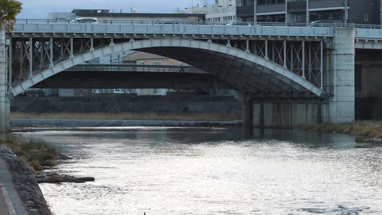 Arch Bridge over River in Cityscape