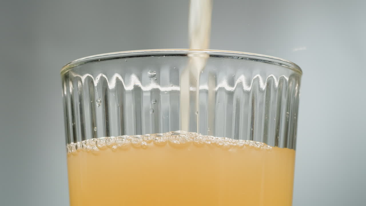 Orange or white wine bottle and glass, spanish french apple cider pouring, pouring of ecological natural wine.