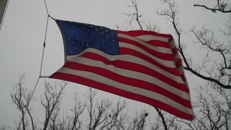 american flag waving in the wind on a cloudy day in slow motion