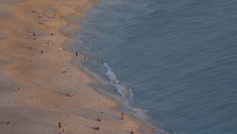 vista del atardecer de una playa con gente disfrutando de la vista en portugal