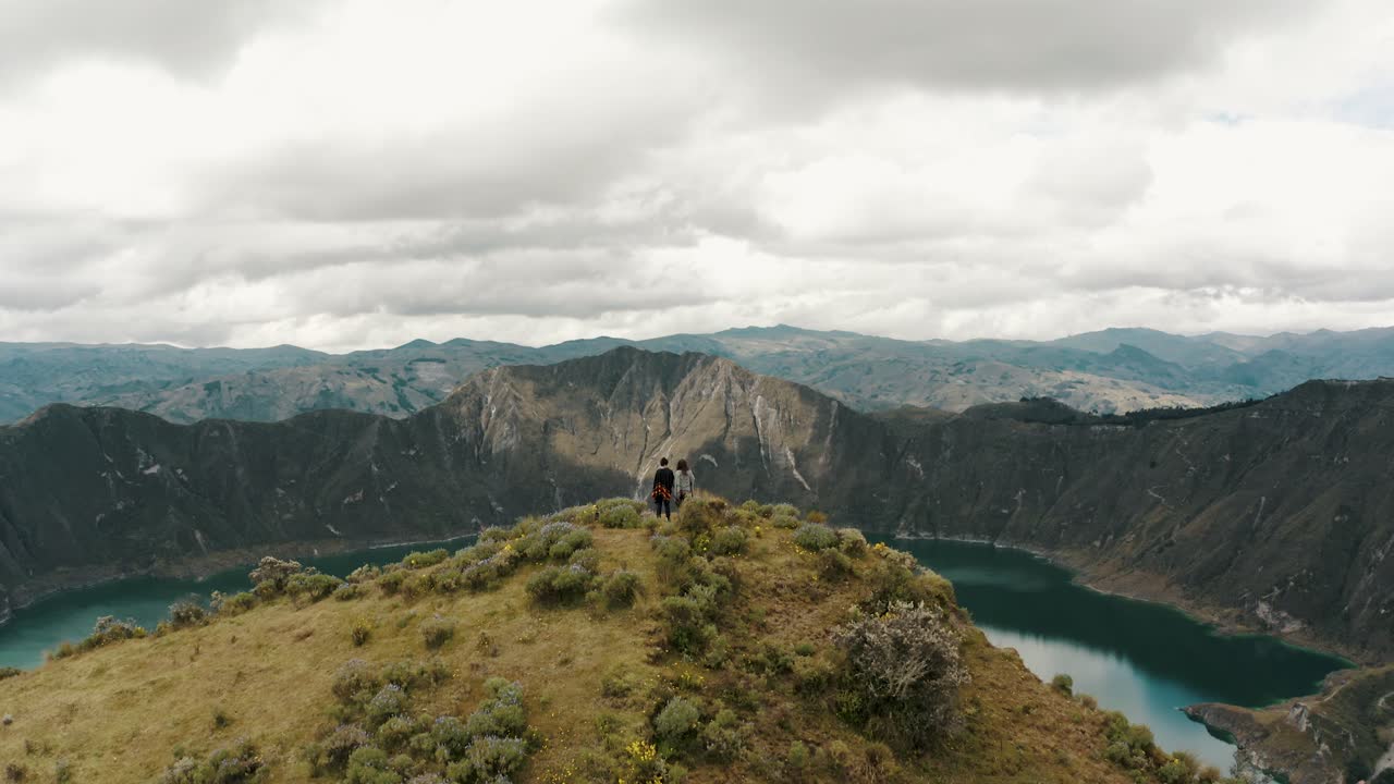 gente en la cumbre del circuito de quilotoa que revela el lago del volcán en ecuador