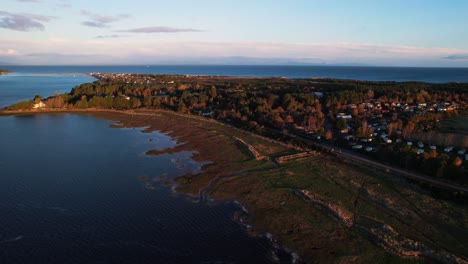 Aerial-shot-of-a-caravan-site-right-on-the-coast-of-the-Scottish-city-during-sunset