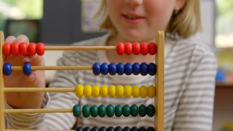 mid section of caucasian schoolgirl learning mathematics with abacus in the classroom 4k