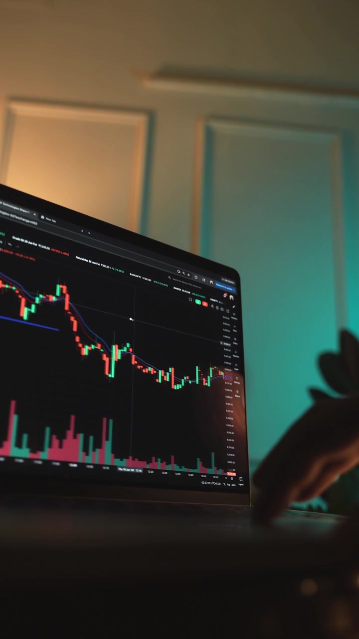 Trader che analizza grafici di borsa su un laptop tramite una piattaforma di brokeraggio