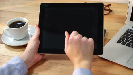 hombre de negocios usando una tableta digital en el escritorio con una taza de café y una computadora portátil en la mesa