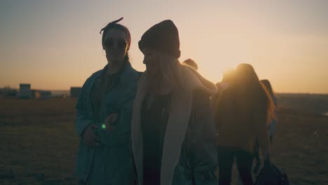 group-of-smiling-girls-and-guys-walk-along-field-to-campsite