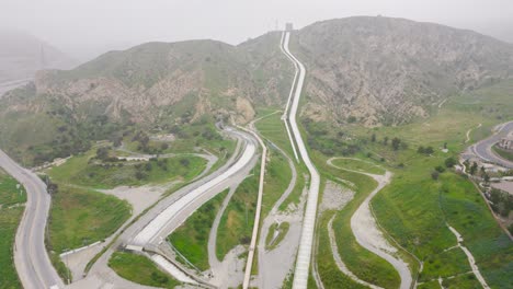 aerial drone time lapse of a residential neighborhood next to los angeles aqueduct cascades with water being releases as a flood prevention