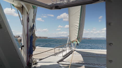 Front-view-of-catamaran-sailboat-sailing-on-a-sunny-summer-day-in-the-coast-of-Valencia,-Spain