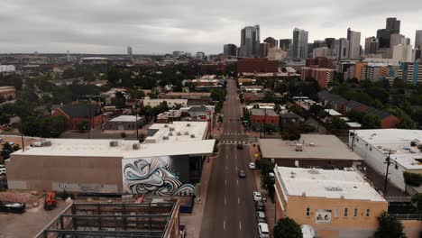 a rising pan along santa fe blvd just south of denver capturing the skyline on a gloomy day