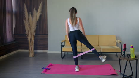 woman doing leg exercises with resistance band at home