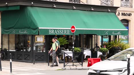 los peatones y los vehículos pasan por una brasserie