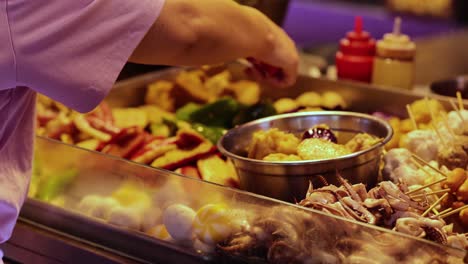 vendor preparing meatballs at a food stall