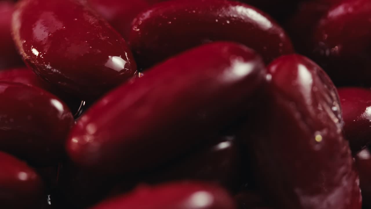 Fagioli rossi in scatola, fagioli conservati su sfondo rotante, primo piano, vista laterale. Fagioli biologici al vapore. Fagioli in salamoia per un piatto messicano