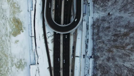 vista superior del tráfico de automóviles en el cruce de la autopista en la ciudad de invierno. vista de aviones no tripulados de automóviles que conducen en la cruce de nieve en la ciudad. cruce de invierno en la autopista urbana