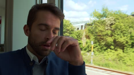 un pasajero cansado del tren se queda dormido.