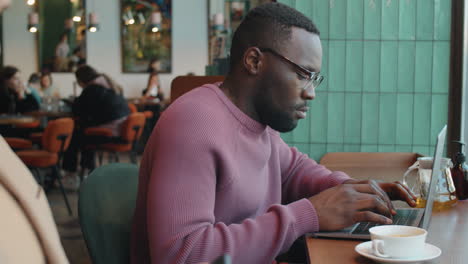 Black-Businessman-Working-on-Laptop-in-Cafe