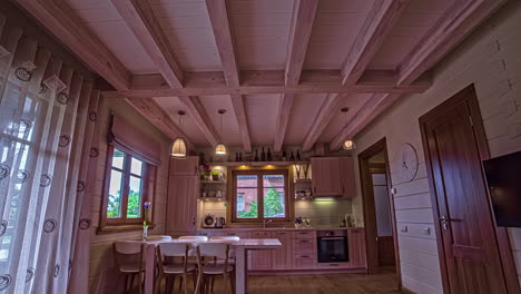 Holzhaus-Mit-Schöner-Küche-Und-Esszimmer-In-Rosa-Farben-Gestrichen,-Ergänzt-Durch-Pendelleuchten