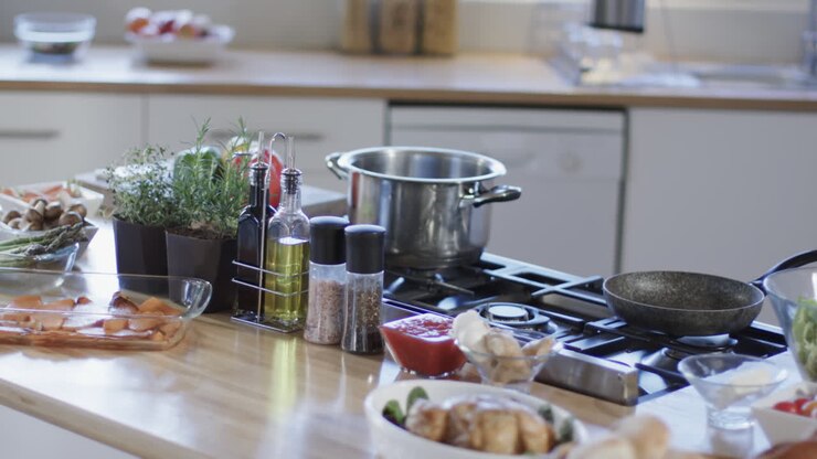 Vista generale del piano di lavoro e del piano cottura della cucina con spezie e utensili, con spazio per il testo.