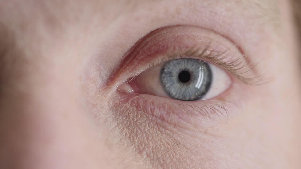 가까이 서서 파란 눈의 남자가 주위를 둘러보며 눈을  ⁇ 박이는 사려 깊은 성찰적인 광학적 감정