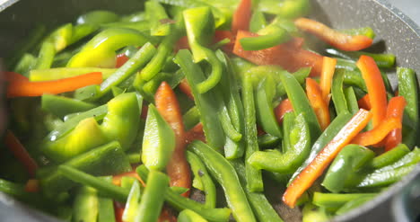 frying green and red pepper on pan