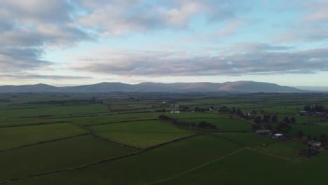 Aerial-rising-shot-of-the-Comeragh-Mountain-Range-from-the-coast-at-sunset-on-a-winter-day-in-Waterford-Ireland