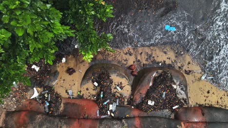 rubbish washed up against a tidal wall on a beach in far northern australia