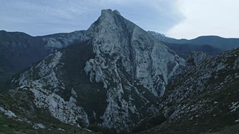 Anonymous-hiker-walking-on-rocky-mountains-under-sky