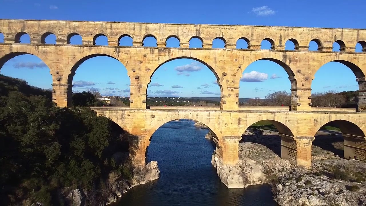 Pont du Gard. Gard-broen. Romersk akveduktbro over elven. Luftfoto med utzoomende kamerabevegelse. Verdens høyeste romerske bro, med tre nivåer av buer. Remoulins. Frankrike.