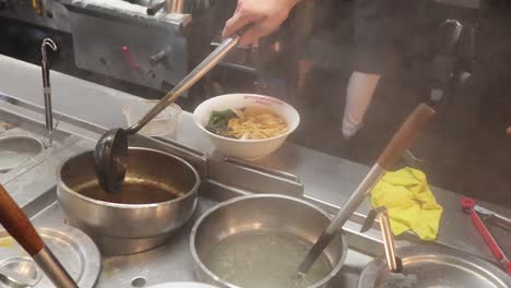 chef preparing noodles in a busy kitchen