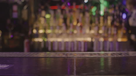 close up of waiter serving drinks to unrecognizable couple sitting at bar counter 1