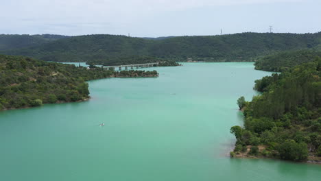 dos hombres en un bote de remo entrenando el lago saint cassien disparo aéreo siguiendo a ellos