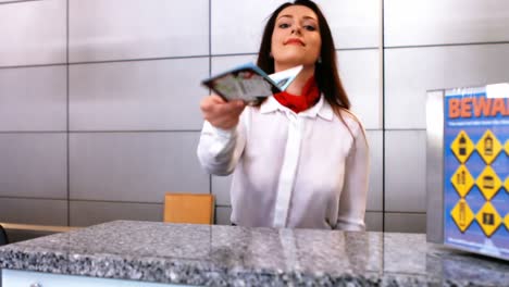 Female-airport-staff-checking-passport-at-check-in-desk