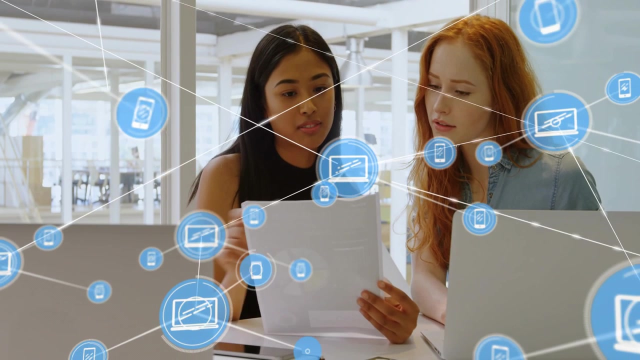 One blue icon appearing over pages and expanding into tech network while two women reviewing laptop