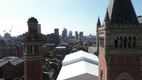 aerial drone flight between the two towers of manchester crown court with a skyline view of manchester skyscrapers