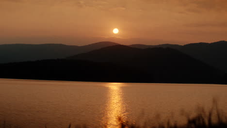 sunset over a lake with mountains