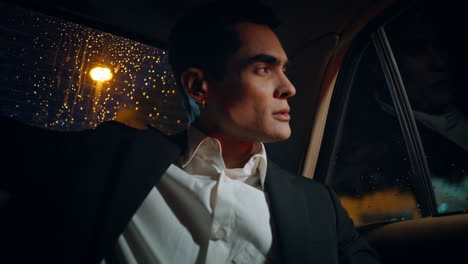 Rich businessman riding car at night time closeup. Director sitting automobile