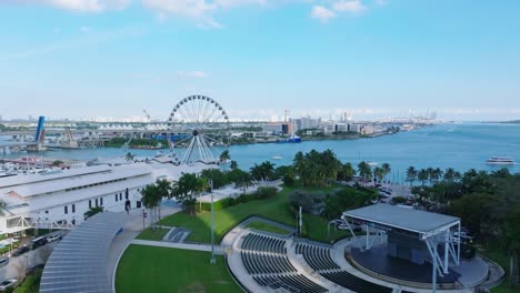 Drone-Elevándose-Sobre-El-Parque-Frente-A-La-Bahía-En-Miami,-Florida,-El-Puerto-Y-La-Noria