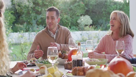video de un padre caucásico feliz contando una historia en la mesa de la cena familiar al aire libre