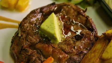 Close-up-of-plate-with-steak-with-garlic-butter,-grilled-vegetables-and-potatoes