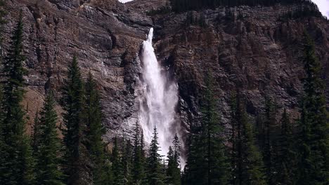 Una-Gran-Cascada-Desde-La-Distancia-Con-Un-Bosque-Al-Frente