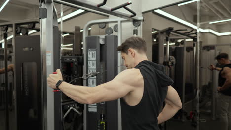 Mascular-bodybuilder-doing-rear-delt-cable-fly-exercise-in-slow-motion