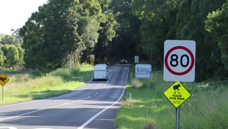 car and trailer driving on a country road