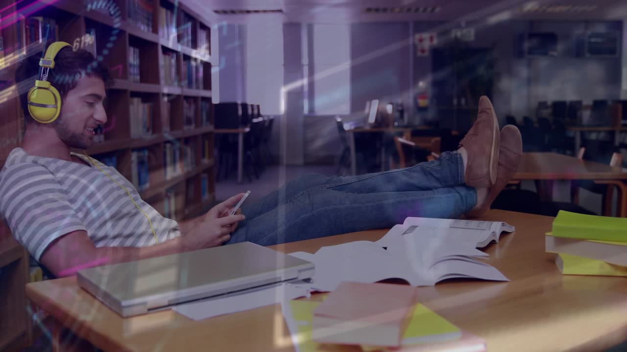 Male student tapping smartphone for study, in yellow headphones, light overlays moving across frame