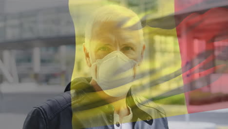 bélgica ondeando una bandera contra el retrato de un anciano caucásico con una máscara facial en la calle