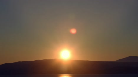 Timelapse-De-La-Puesta-Del-Sol-Sobre-El-Mar-A-La-Zona-Montañosa