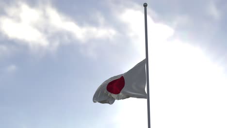bandera de japón a media asta en el viento