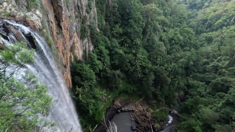 cascading waterfall flows through a dense green forest