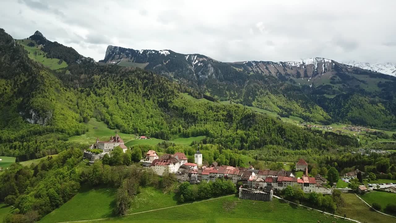 Medieval town of Gruyeres dominated by the castle located in the upper valley of the Saane-Sarine river, and gives its name to Gruyere cheese. Greyerz, Fribourg, Switzerland, drone orbiting shot