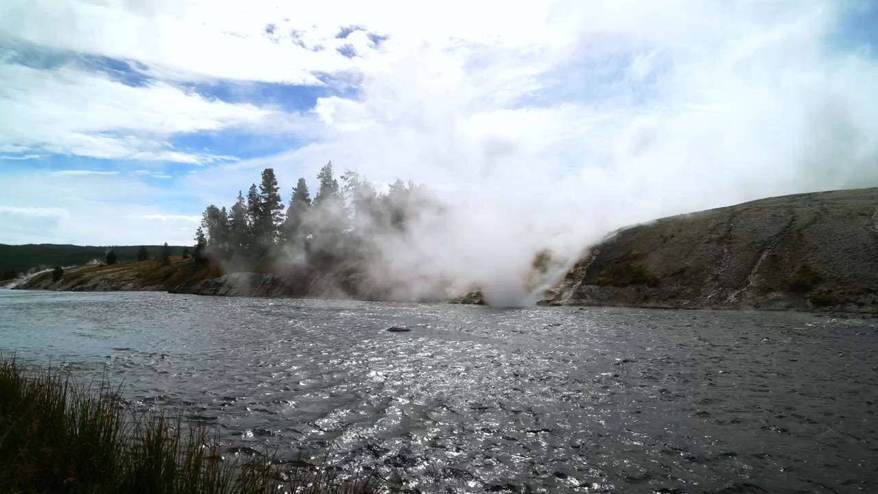 Grand Prismatic Kaplıcası, en büyük sıcak su kaynakları buharlı havuzu, Orta Gayzer Havzası, Firehole Nehri, Wyoming ABD, Yellowstone Milli Parkı, doğa manzarası, nehir kıyısı, Midway Ahşap Yürüyüş Yolu, güneşli mavi gökyüzü, sabah durağanlığı.